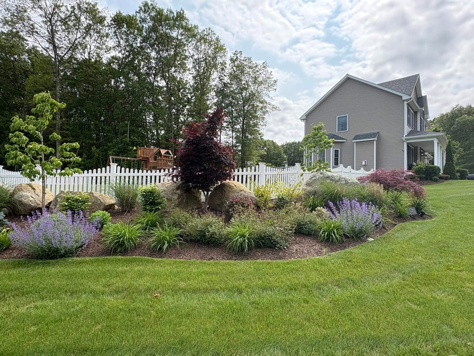 A finished planting bed and stonework by RootedByEl